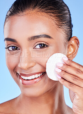 Buy stock photo Happy woman, face and portrait with cotton pad for healthy skincare, cosmetics or aesthetic on blue background in studio. Indian model, facial cleaning and beauty of dermatology, shine or wipe makeup