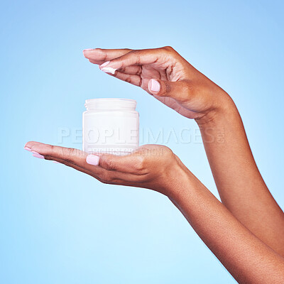 Buy stock photo Skincare, cream and product with hands of woman in studio for beauty, facial or moisturizer. Spa treatment, health and collagen with closeup of person on blue background for lotion and sunscreen