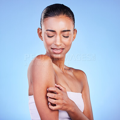 Arm pain, stress and sad woman in studio with arthritis, osteoporosis or emergency on blue background. Shoulder, accident and unhappy lady person with pressure point massage for osteoarthritis relief