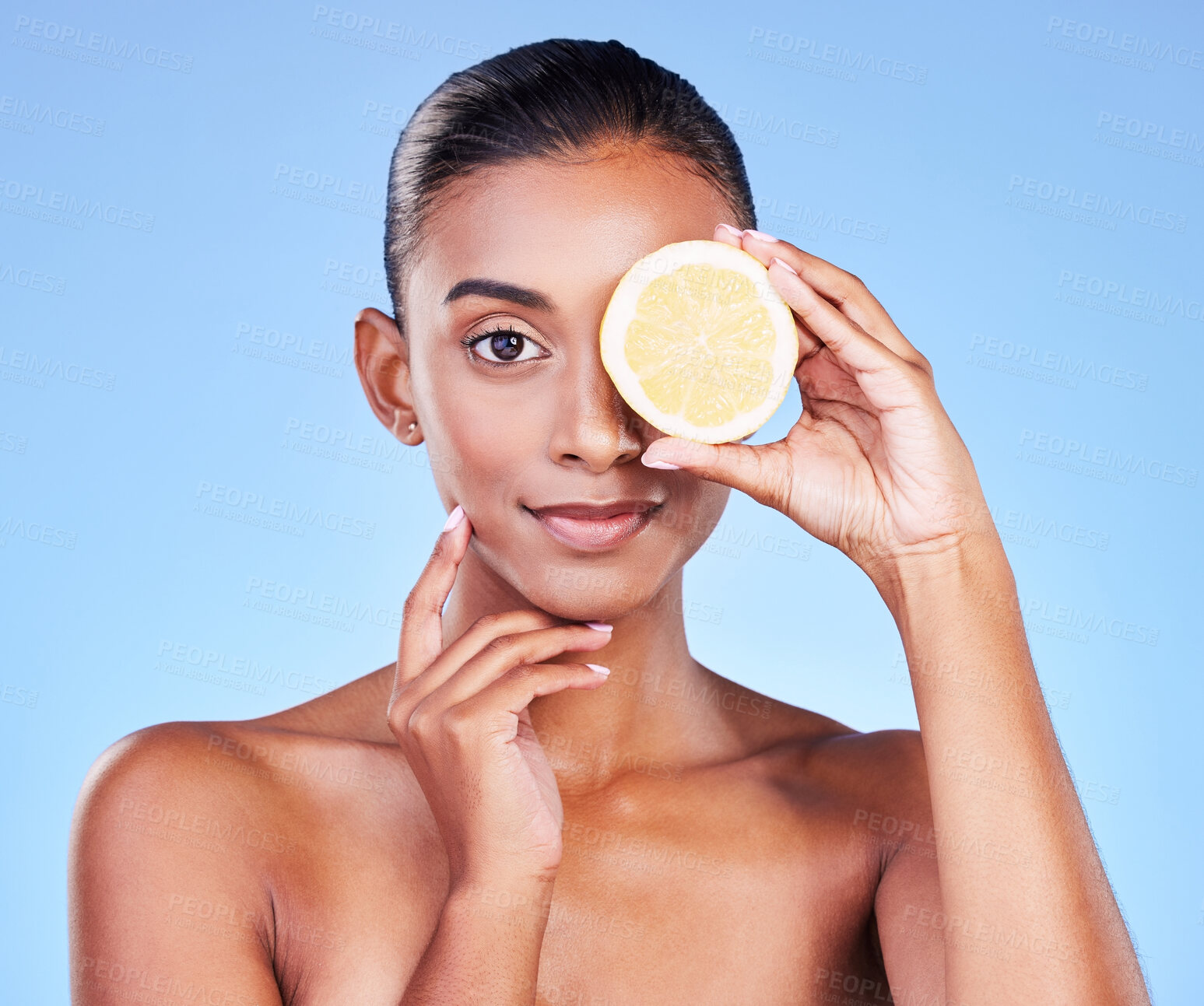 Buy stock photo Portrait, woman and lemon on eyes in studio for vitamin c cosmetics, eco friendly beauty or detox. Face of indian model, healthy skincare or citrus fruit of sustainable dermatology on blue background