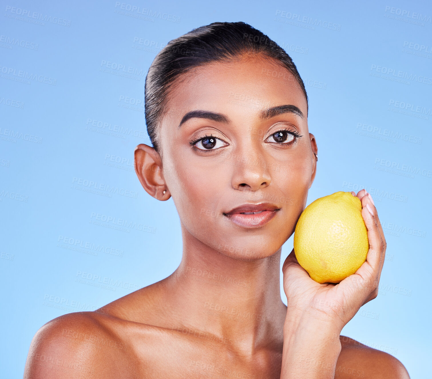 Buy stock photo Lemon, portrait or natural skincare of woman in studio for vitamin c benefits, eco cosmetics or nutrition. Face of indian model, healthy beauty or citrus fruit of vegan dermatology on blue background