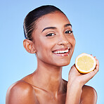 Lemon, portrait and woman in studio for beauty, vitamin c cosmetics and natural nutrition. Happy indian model, healthy skincare and citrus fruits for vegan dermatology, detox diet and blue background