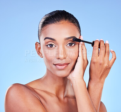 Buy stock photo Woman, mascara and makeup, portrait and brush with transformation and beauty product on blue background. Eyelash extension, cosmetology and cosmetics with Indian model, volume and change in a studio