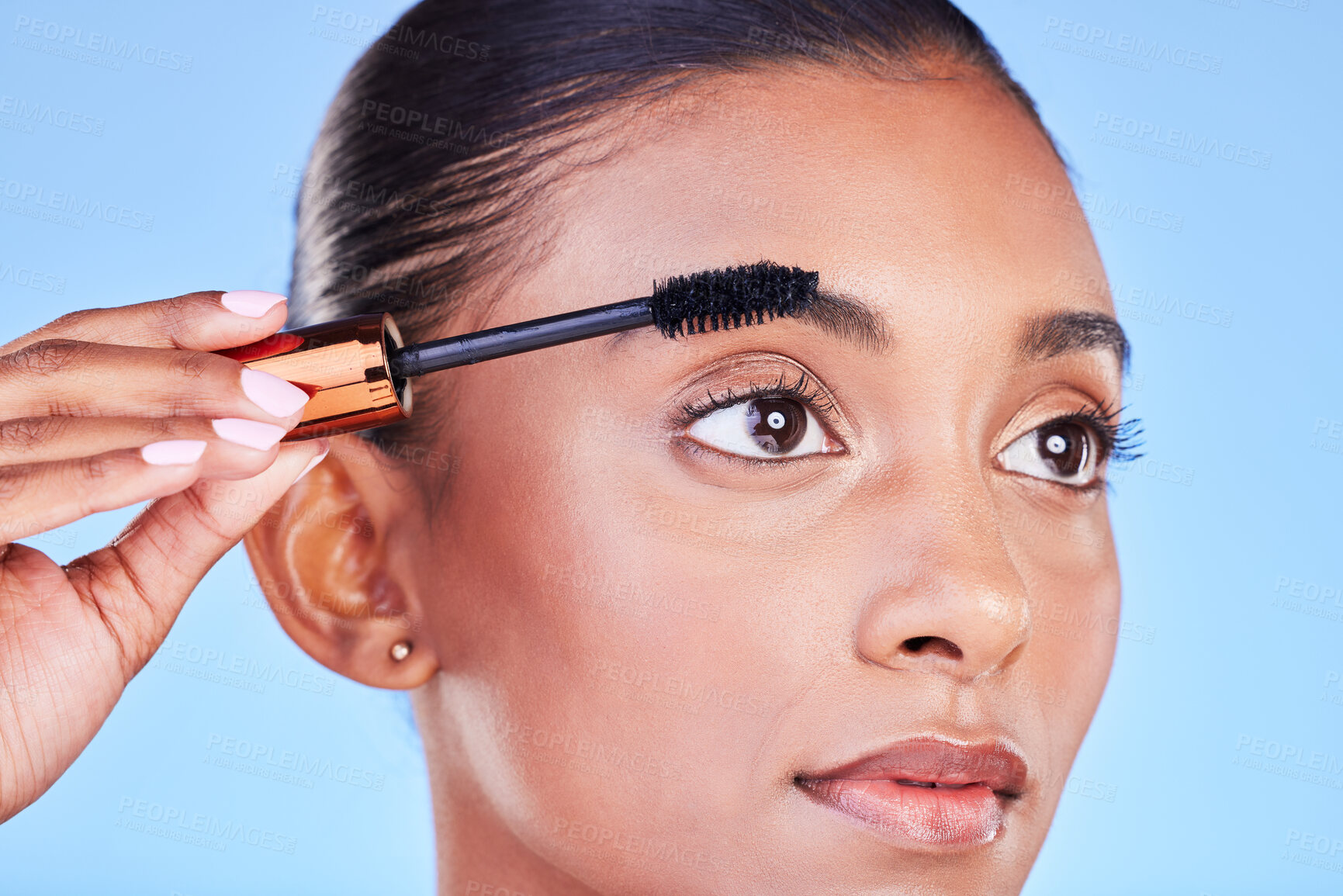 Buy stock photo Woman, face and mascara in beauty makeup, cosmetics or eye brush against a blue studio background. Closeup of female person applying eyeshadow on eyelashes for volume, product or facial treatment