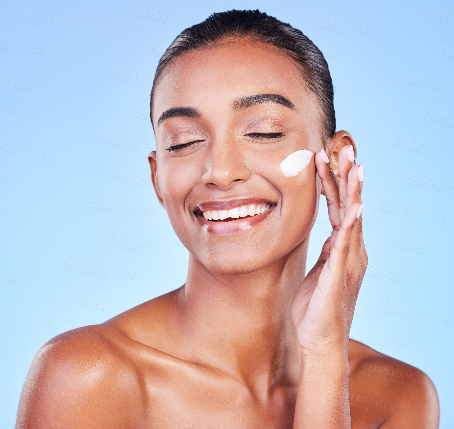 Buy stock photo Skincare, cream and smile with woman and sunscreen in studio for beauty, facial or moisturizer. Spa treatment, cosmetics and collagen with face of person on blue background for makeup, glow or lotion