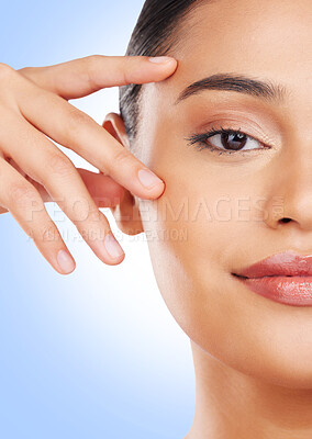 Buy stock photo Half face, closeup or woman with skincare, cosmetics or dermatology on a blue studio background. Portrait, person or model with beauty, luxury or wellness with self care, shine or glow with treatment