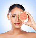 Beauty skincare, portrait and woman with grapefruit for organic collagen treatment, natural self care or fruit benefits. Vitamin C, citrus product or studio face of wellness person on blue background
