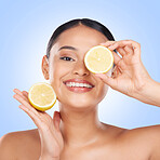 Woman, face and lemon with natural beauty, skincare and vitamin c cosmetic product isolated on blue background. Model in portrait with facial, fruit and dermatology, skin glow and citrus in studio