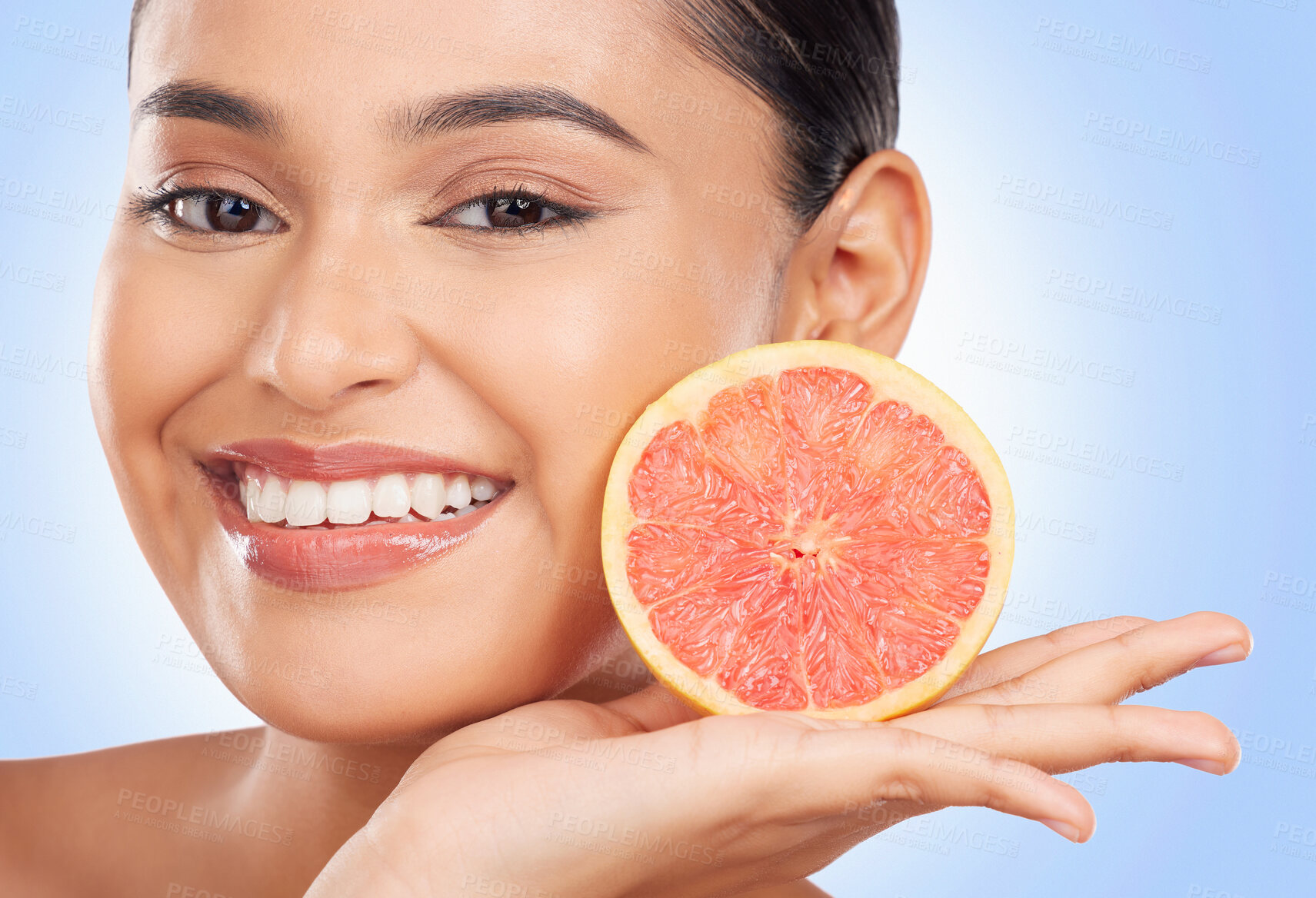 Buy stock photo Portrait, beauty and grapefruit with a natural woman in studio on a blue background for health or wellness. Face, skincare and smile with a happy young model holding fruit for detox or antioxidants