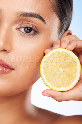 Buy stock photo Beauty, portrait and studio woman with lemon for organic anti aging treatment, skincare detox or aesthetic cosmetics. Vitamin C benefits, spa wellness or half face of closeup model on blue background