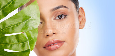 Buy stock photo Woman with palm leaf, face and beauty, sustainable skincare and natural isolated on blue background. Wellness, skin glow and eco friendly cosmetics with mockup space, dermatology portrait in studio