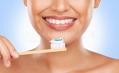Brushing teeth, toothpaste and dental, woman and health with wellness isolated on blue background. Closeup, mouth and bamboo toothbrush, oral care and orthodontics with hygiene and grooming in studio