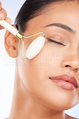 Buy stock photo Woman, face roller and massage in studio for skincare, grooming and aesthetic dermatology on white background. Model, crystal cosmetics and facial beauty tools for lymphatic drainage, shine and glow