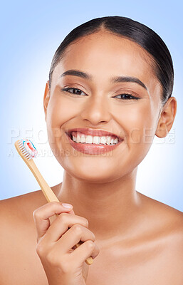 Buy stock photo Happy woman, portrait and toothbrush in studio for dental cleaning, gingivitis or gums on blue background. Face of model, toothpaste and brushing teeth with bamboo for oral hygiene, healthy and smile