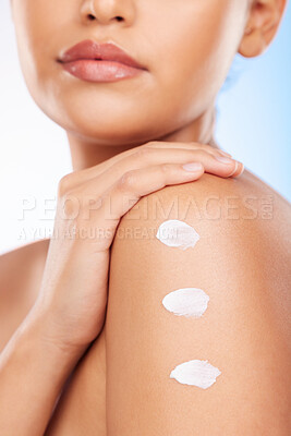 Buy stock photo Closeup, shoulder and woman with cream, dermatology or wellness on a blue studio background. Zoom, person or model with beauty, creme or lotion with shine, product or glow with aesthetic or cosmetics