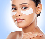 Skincare, portrait and woman with eye patch for anti aging luxury skin glow on blue background. Cosmetics, facial detox and face of model with solution or collagen product for dermatology in studio.