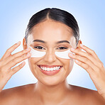 Skincare, eyes and portrait of happy woman with collagen pad for anti aging or skin glow on blue background. Cosmetics, facial beauty and face of model with patches or mask for dermatology in studio.