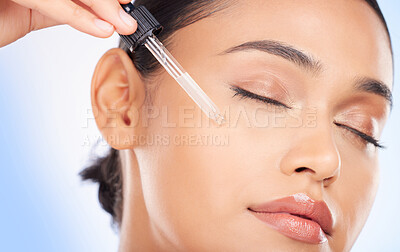 Buy stock photo Essential oil, facial and woman in studio for skincare, wellness or hydration serum application on blue background. Hyaluronic acid, vitamin c or retinol for lady face, collagen or cosmetic treatment