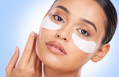 Buy stock photo Portrait, beauty and eye mask with a natural woman in studio on a blue background for antiaging treatment. Face, skincare and wellness product with a young model at the salon for a facial application