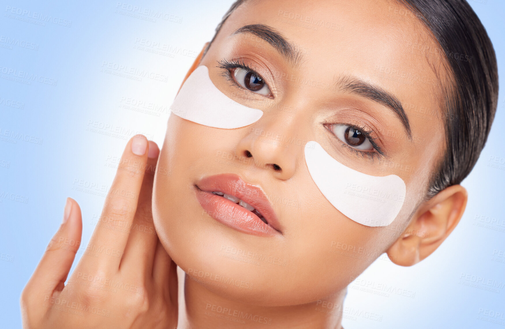 Buy stock photo Portrait, beauty and eye mask with a natural woman in studio on a blue background for antiaging treatment. Face, skincare and wellness product with a young model at the salon for a facial application