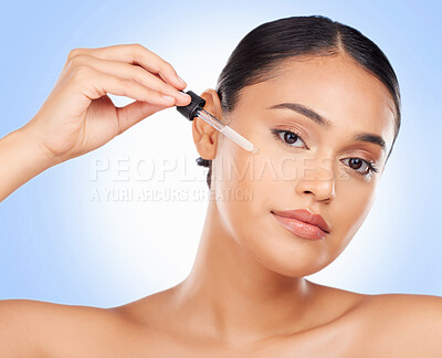 Buy stock photo Skincare, portrait and woman in studio with oil for beauty, wellness or serum application on blue background. Hyaluronic acid, vitamin c or retinol facial for female face, mask or cosmetic treatment