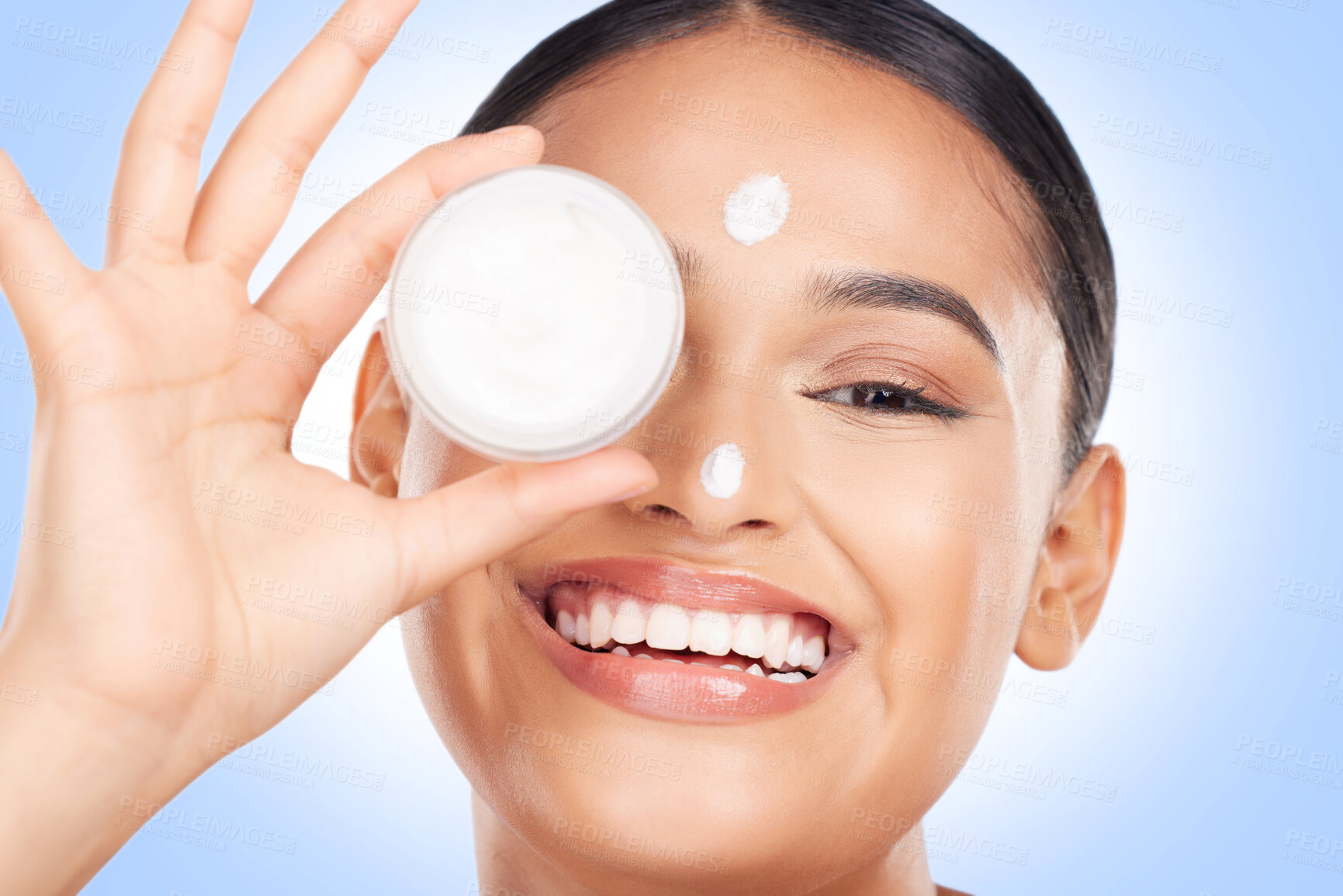 Buy stock photo Portrait, happy woman and cream container for face, aesthetic skincare and shine on blue background. Young model, facial beauty and moisturizer jar for sunscreen, cosmetics and dermatology in studio