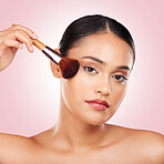 Cosmetic, makeup brush and portrait of woman in studio with a glamour, beauty or face routine. Glow, self care and headshot of young female model with cosmetology product isolated by pink background.