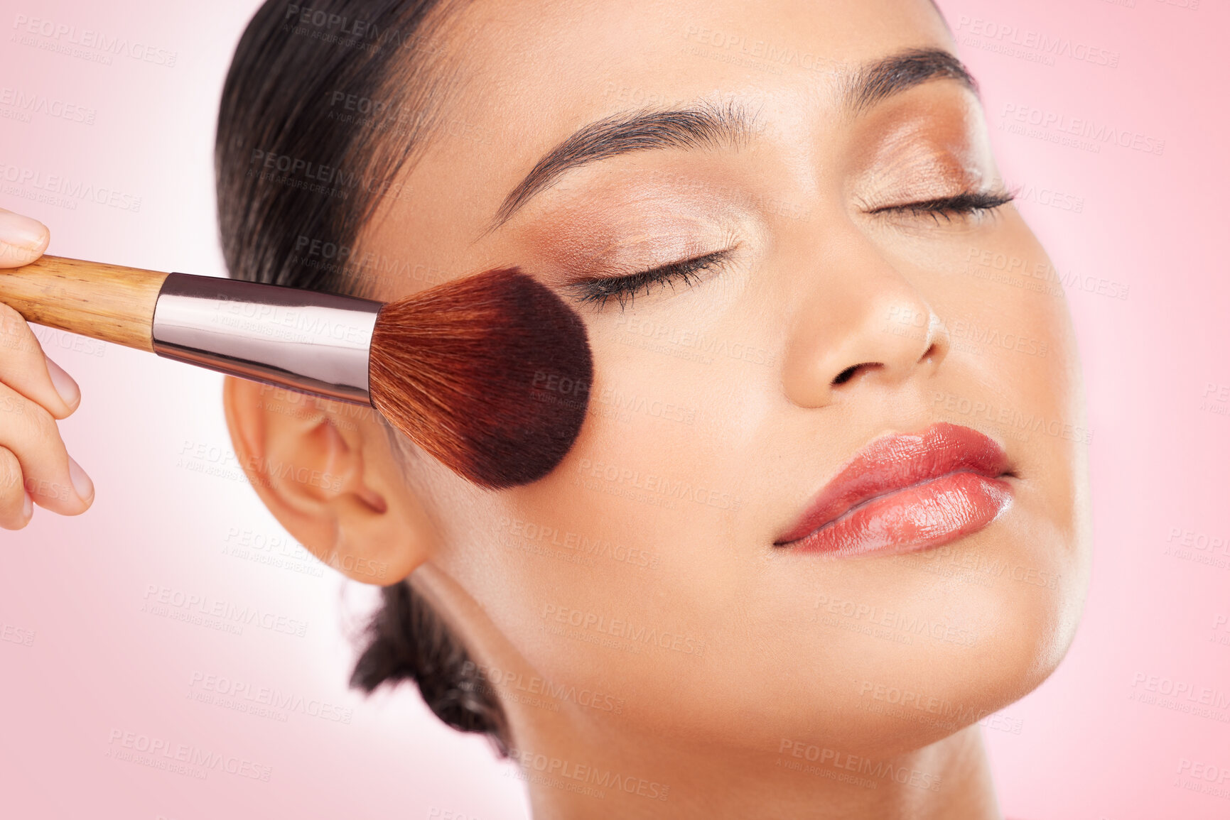 Buy stock photo Beauty, cosmetics and woman in a studio with a brush for face foundation or glamour routine. Makeup, self care and closeup of young female model with cosmetology product isolated by pink background.