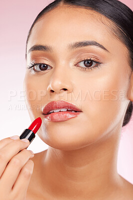 Buy stock photo Portrait, beauty and lipstick with a woman closeup on a pink background in studio for luxury cosmetics. Aesthetic, makeup or product with a young model getting ready to apply red lipgloss to her face