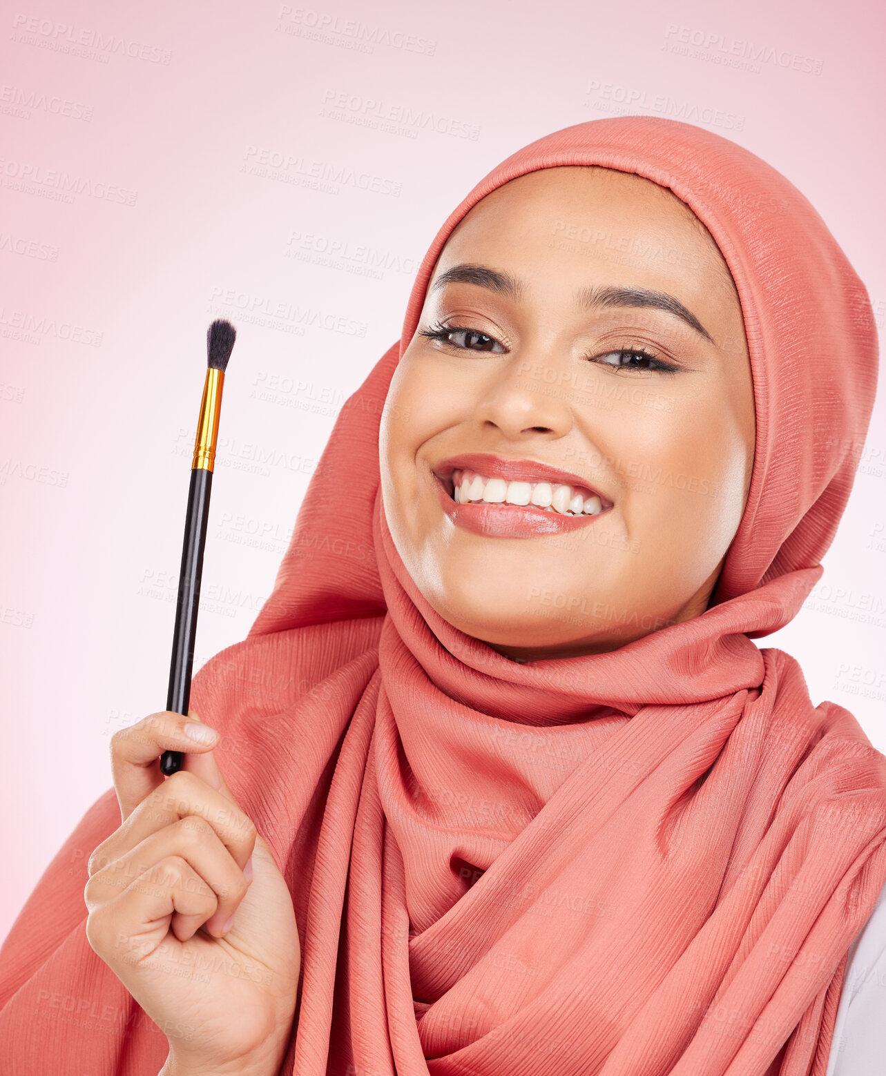 Buy stock photo Portrait, happy and muslim woman with makeup brush in studio with cosmetic application on pink background. Halal, skincare and face of female model with beauty, tool or powder, luxury or satisfaction