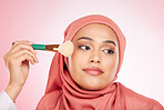 Makeup, foundation brush and muslim woman with a smile from cosmetics and blush in studio. Facial, glow and happy female person with beauty, skincare and shine with a hijab and skin tool for face