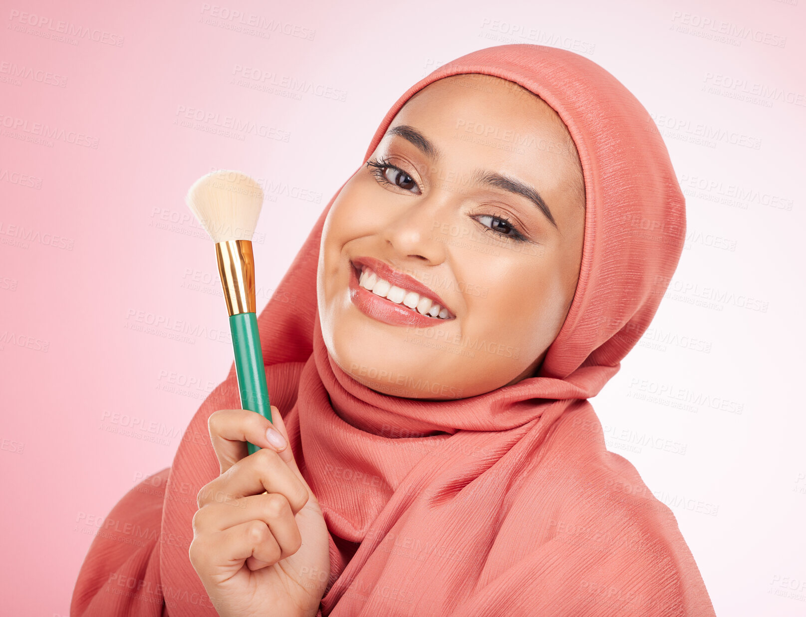 Buy stock photo Smile, portrait and a Muslim woman with a brush for makeup on a pink background. Happy, skincare and an Islamic model with a product for cosmetics, skincare or a product for applying foundation