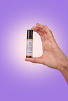 Hand, serum for lips with beauty and skincare, advertising product with dermatology isolated on purple background. Person with cosmetics for skin and promotion, bottle and wellness in a studio