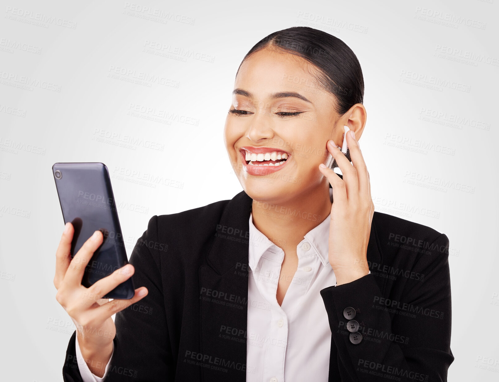 Buy stock photo Smile, phone and earphones with a business woman in studio on a white background for communication. Smile, networking and video call with a happy young employee in a virtual meeting on her mobile