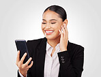 Smile, phone and video call with a business woman in studio on a white background for communication. Networking, music and earphones with a happy young employee typing a text message on her mobile