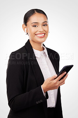 Buy stock photo Portrait, phone and earphones with a business woman in studio on a white background for communication. Smile, networking and music with a happy young employee typing a text message on her mobile