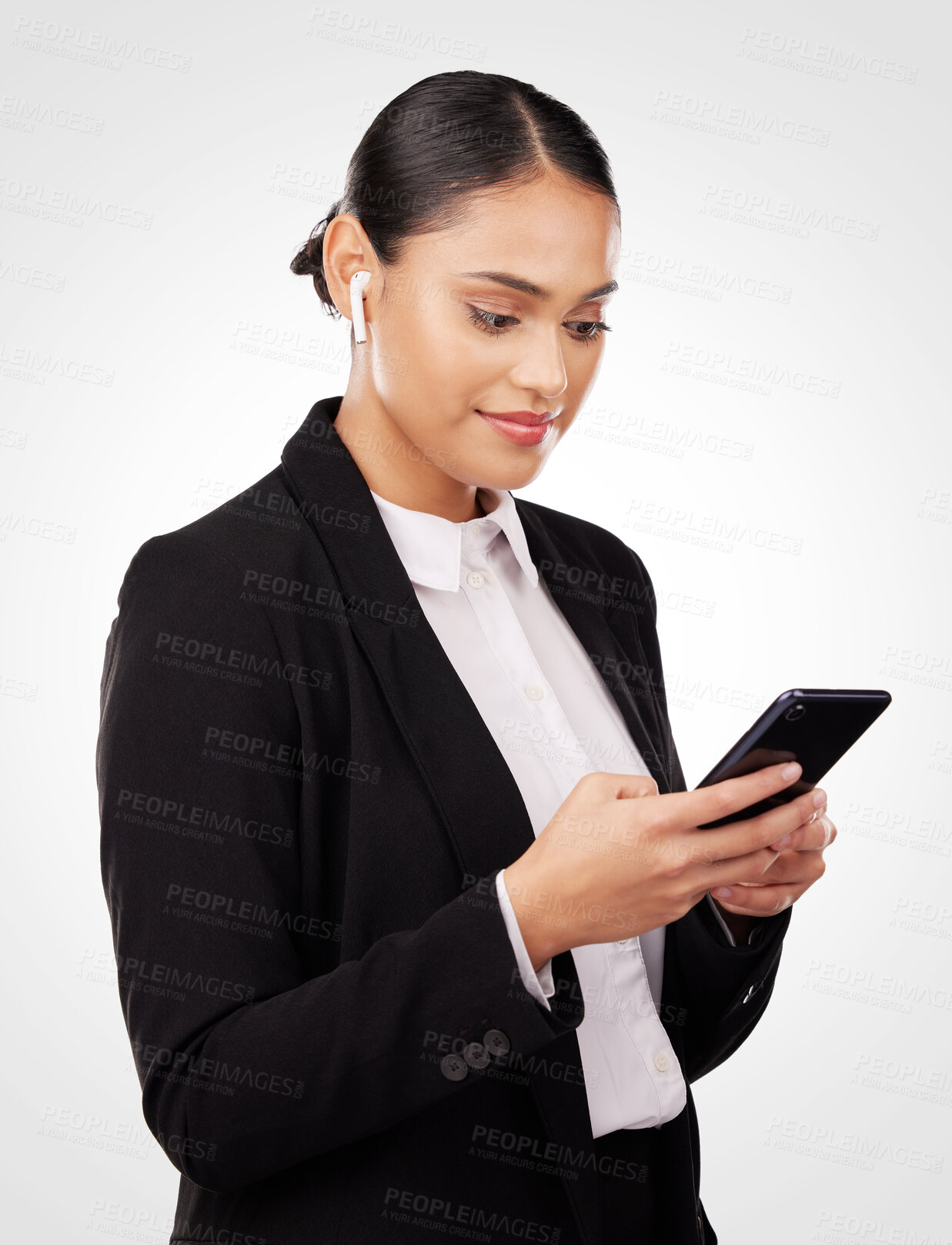 Buy stock photo Communication, phone and earphones with a business woman in studio on a white background for networking. Contact, music and a happy young employee reading or typing a text message on her mobile