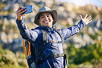 Selfie, smile and a man hiking in the mountains for travel, adventure or exploration in summer. Nature, freedom and photography with a happy young hiker taking a profile picture outdoor in the sun