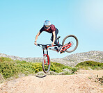 Action, air and man cycling in nature training for a sports competition on trail or path on mountain. Freedom, stunt or cyclist athlete riding bicycle to jump for cardio exercise, fitness or workout