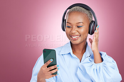 Buy stock photo Music, headphones and black woman with phone in studio for streaming, radio or listen on pink background. Smartphone, app and African lady model with online audio, podcast and earphones for album