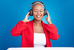 Music, headphones and black woman dance in studio celebration with news, feedback or promo on blue background. Freedom, happy and African model dancing to earphones radio, podcast or audio streaming