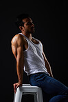 Sexy, thinking and man on chair in studio with fitness inspiration, beauty aesthetic and sensual fashion. Erotic art, sexual body and male model sitting on black background, muscle in dark lighting.