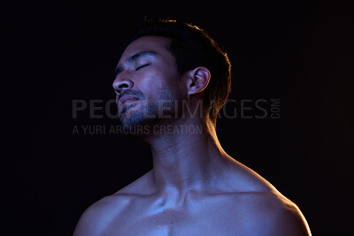 Buy stock photo Blue light, relax man and sleep with creative, art and dark background in studio. Sexy, eyes closed and male model from Indonesia with skin glow, grooming care and wellness for skincare treatment