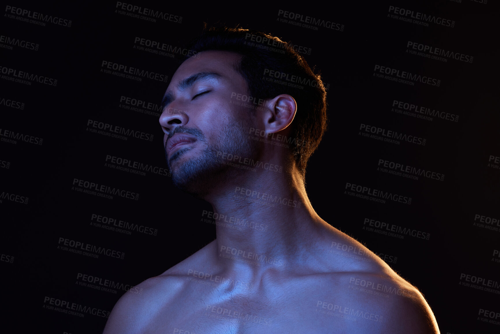 Buy stock photo Blue light, relax man and sleep with creative, art and dark background in studio. Sexy, eyes closed and male model from Indonesia with skin glow, grooming care and wellness for skincare treatment