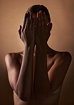Woman, body and hands covering face on dark brown background in studio for creative aesthetic, art deco and skin texture. Shy person, model and hide in shadow for nude beauty, wellness and sensuality