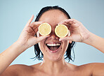 Eyes, smile or happy woman with lemon for skincare or beauty in studio on blue background. Crazy, dermatology shine or funny person with natural fruits, vitamin c or face glow for wellness or health