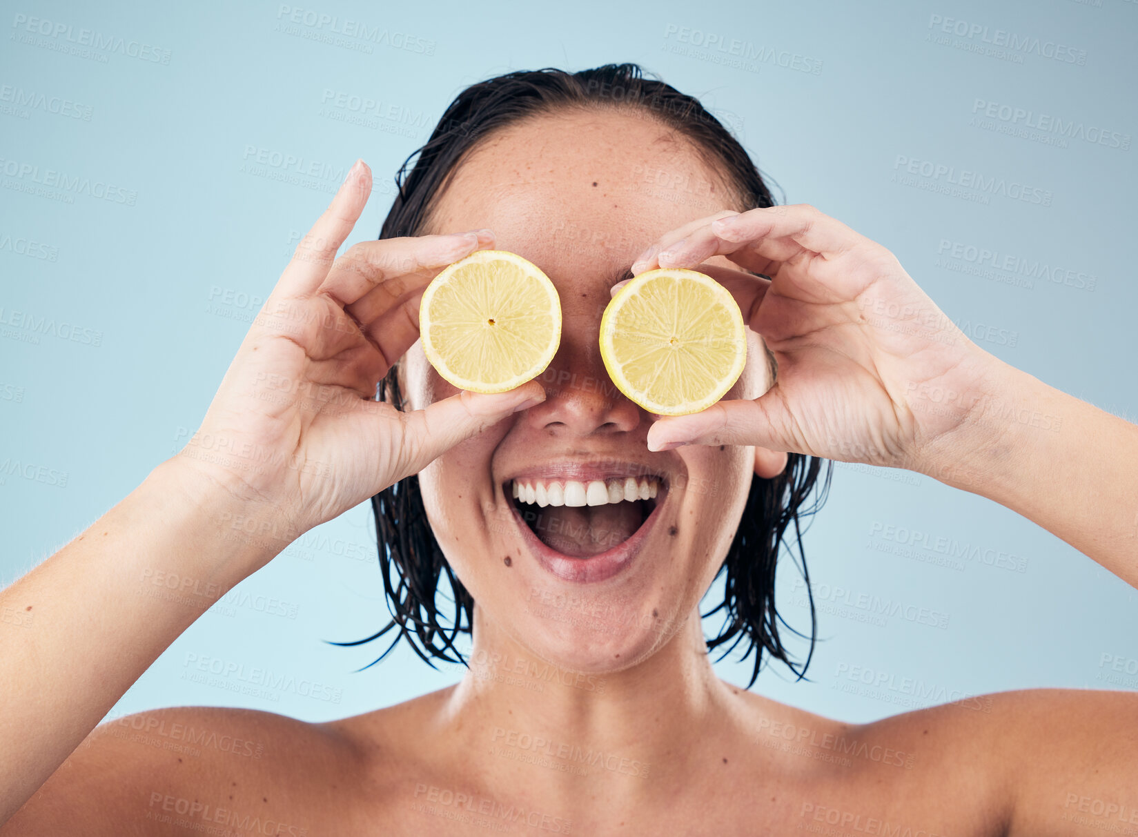 Buy stock photo Eyes, smile or happy woman with lemon for skincare or beauty in studio on blue background. Crazy, dermatology shine or funny person with natural fruits, vitamin c or face glow for wellness or health