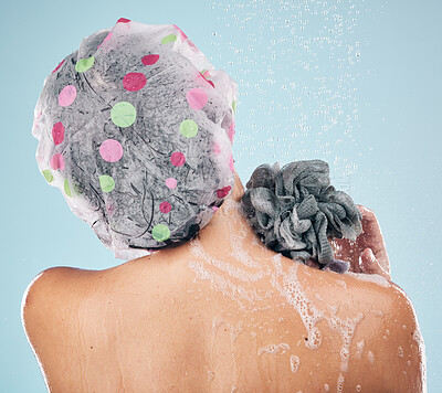 Buy stock photo Person, shower and back in water drops for hygiene, grooming or washing against a blue studio background. Rear view of model in soapy body wash, cleaning or skincare routine under rain in bathroom