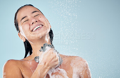 Buy stock photo Skincare, shower and woman smile with loofah in studio isolated on a blue background. Water splash, hygiene and model happy, washing and cleaning to bath in wellness, healthy body and mockup space