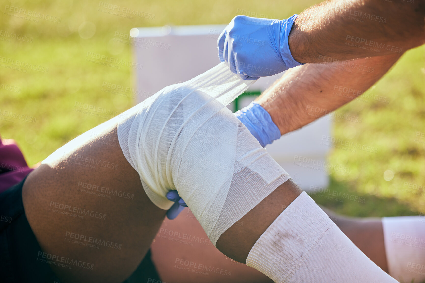 Buy stock photo First aid, sport injury and leg bandage with soccer accident, fitness and massage on a field. Training, workout and physical therapy of knee pain at game with healthcare emergency from exercise 